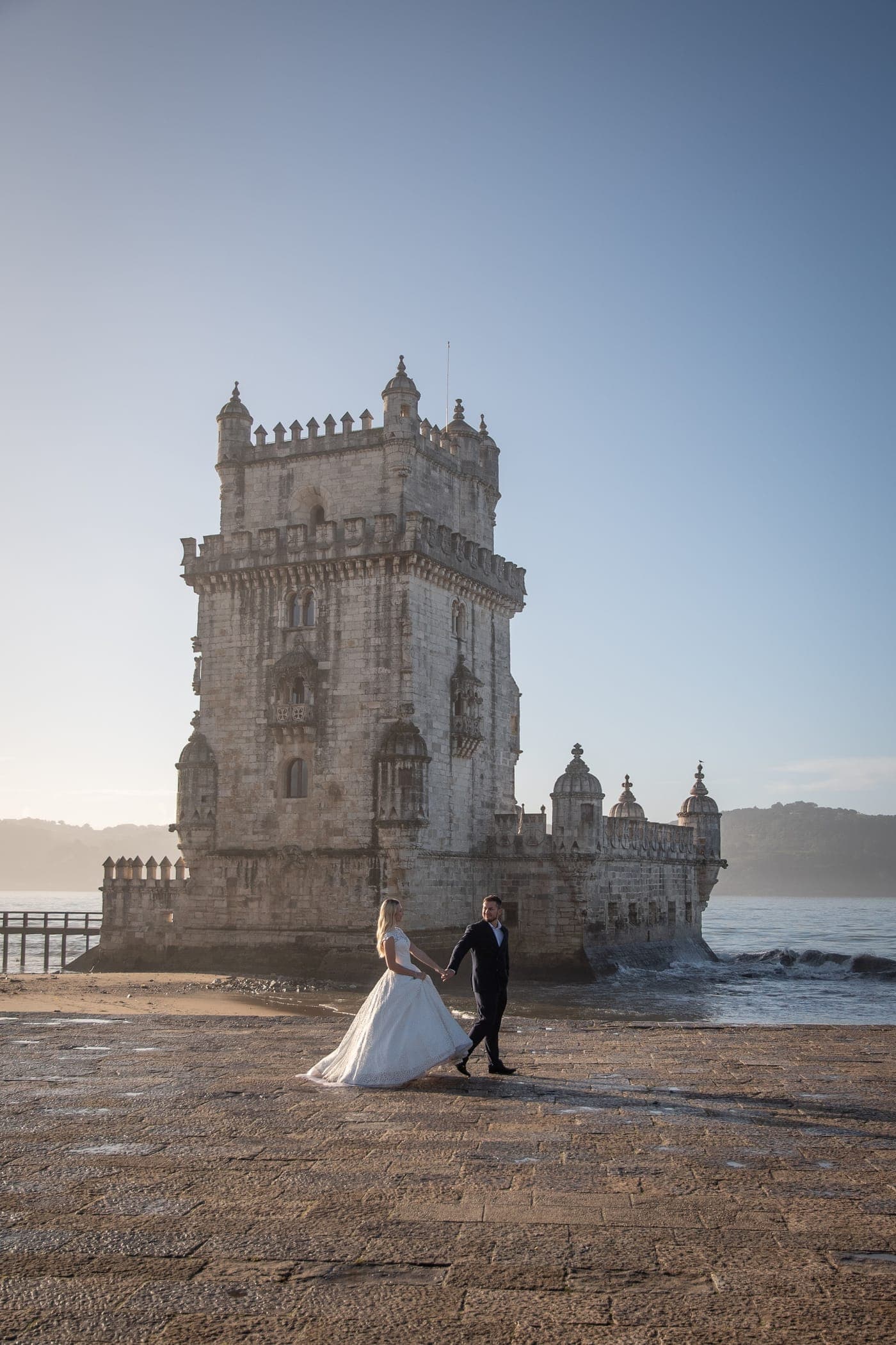 The couple small beneath the tower