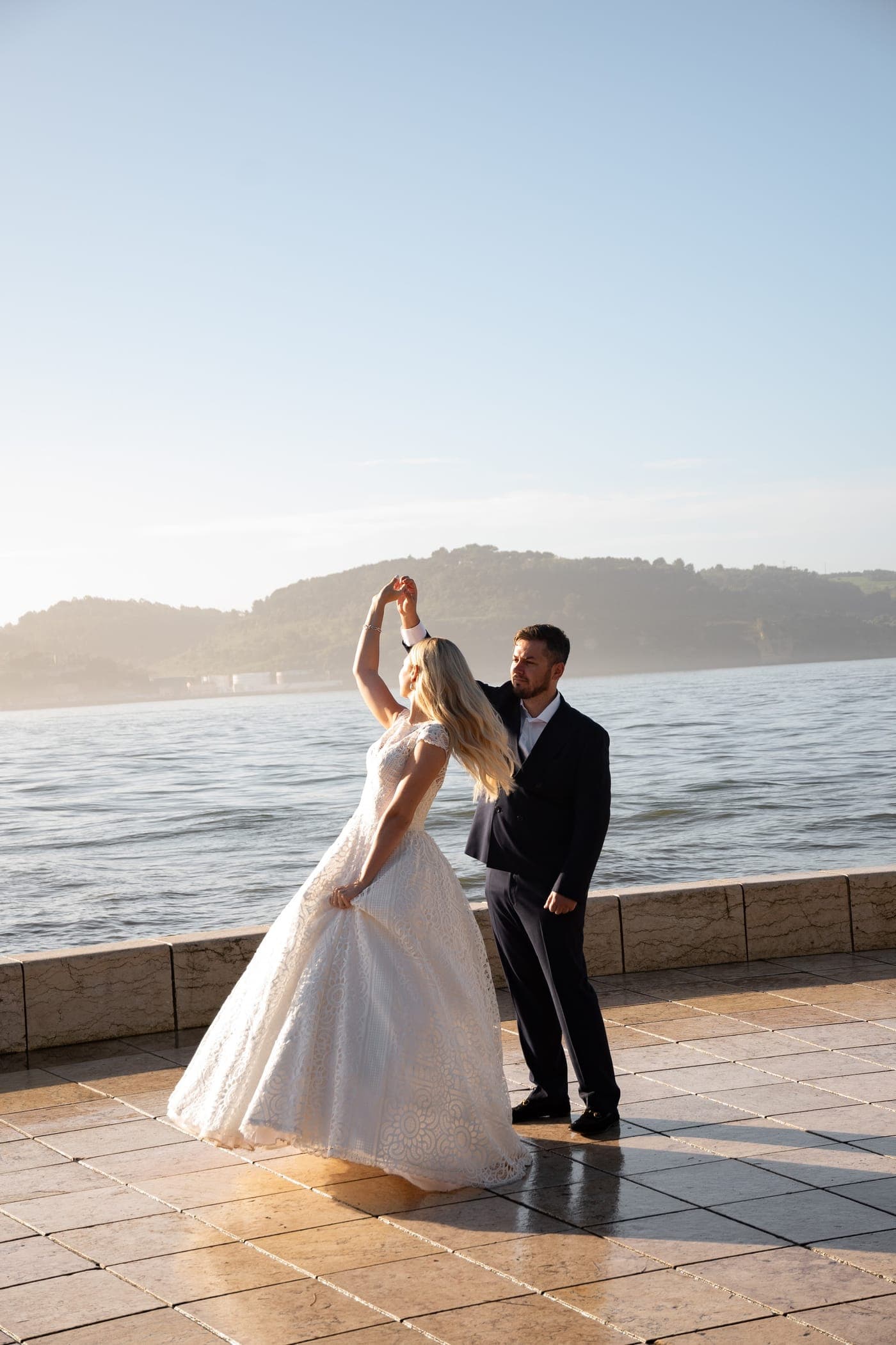 Groom lifting the bride, tower behind