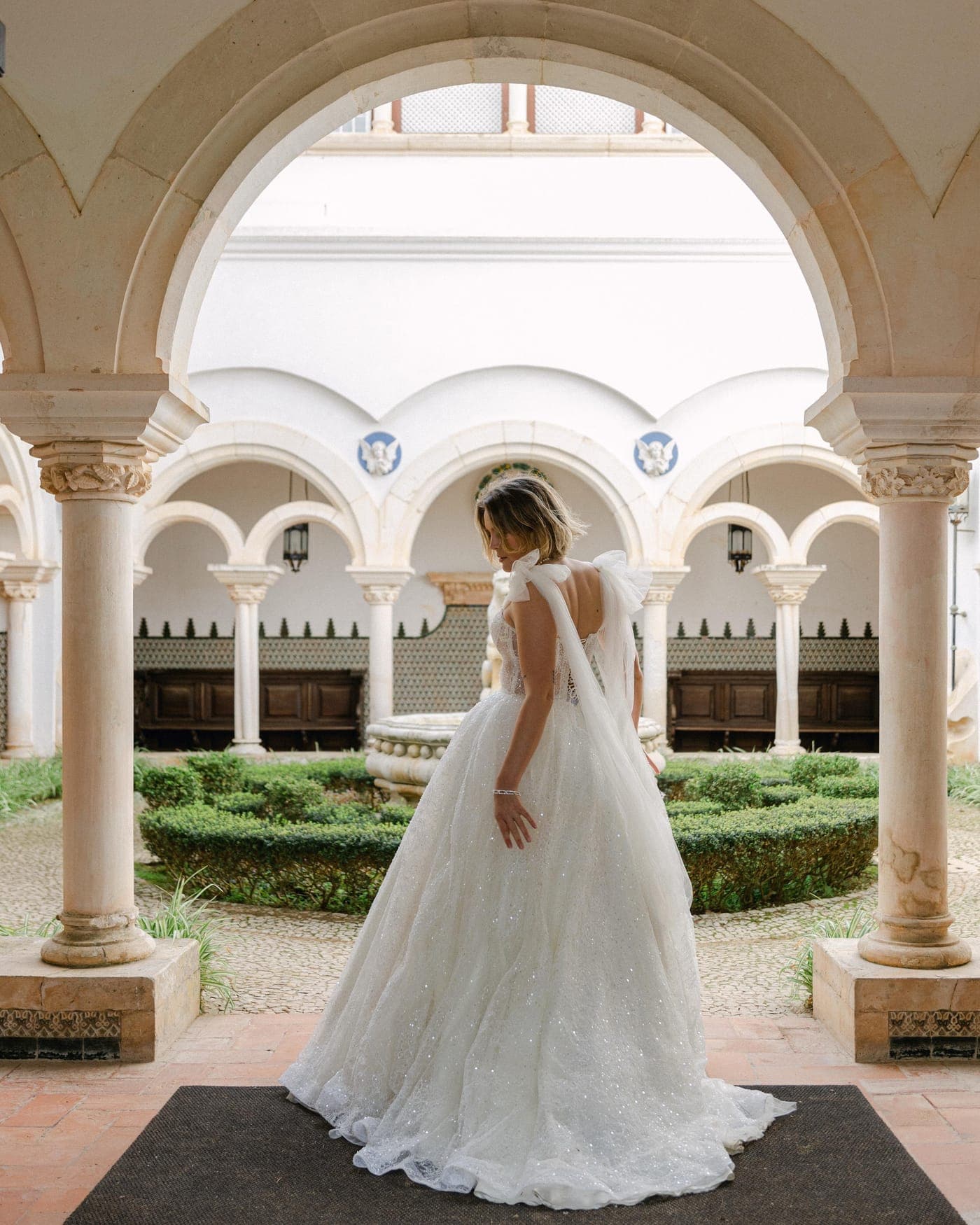 Symmetry: bride framed in the courtyard arch