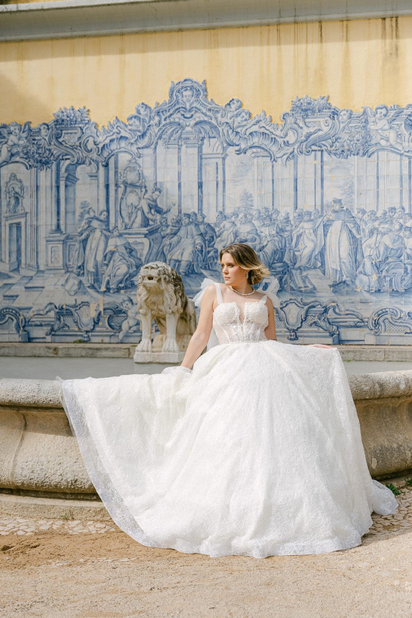 Seated before the azulejo mural and fountain