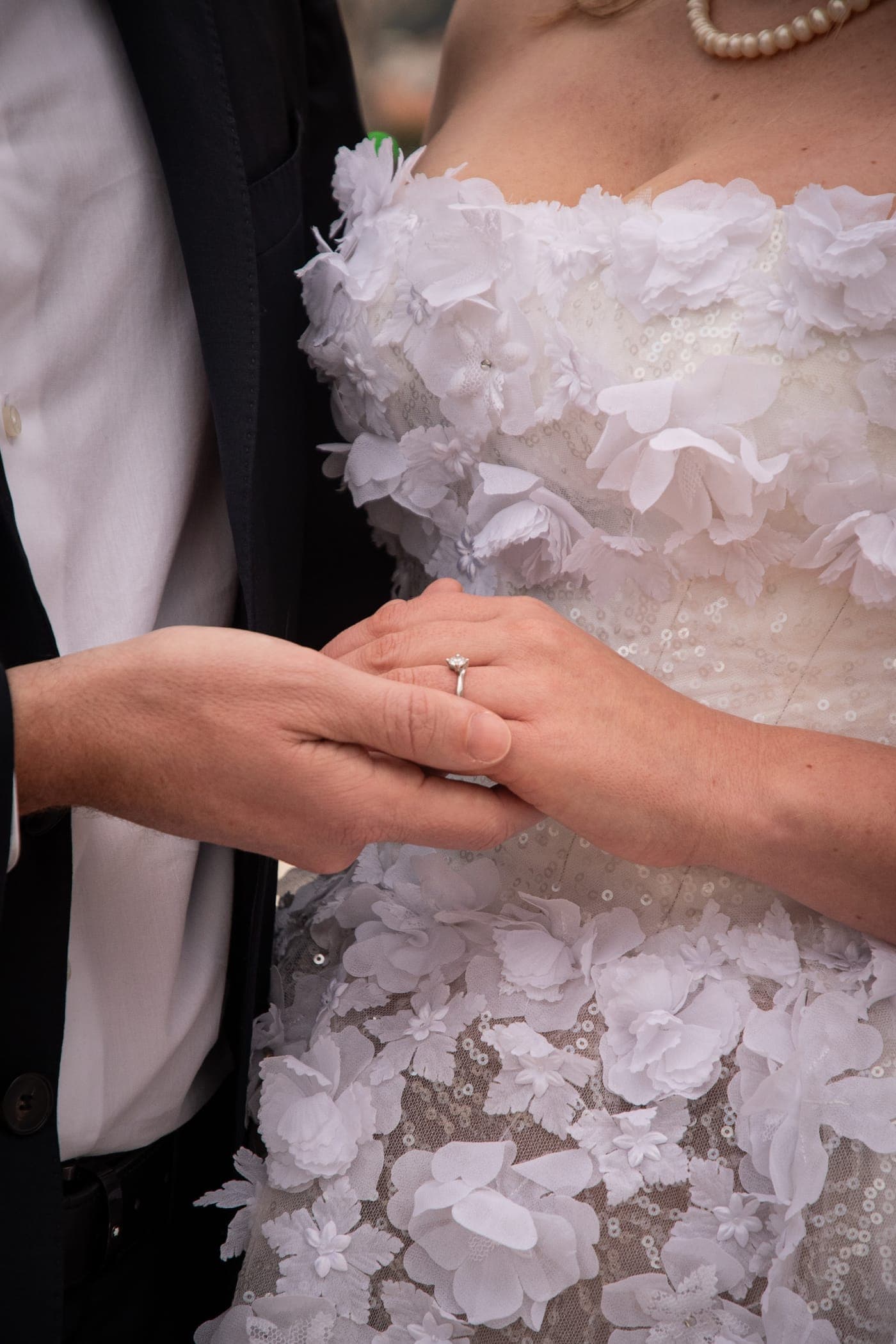 Ring on a hand against the floral bodice