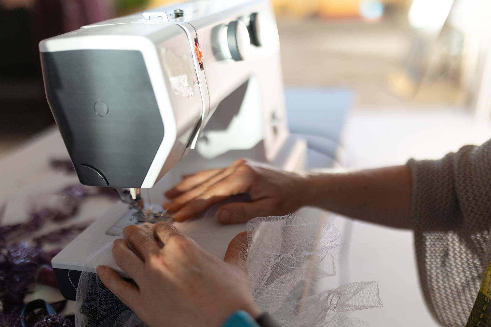 Close view of a sewing machine needle stitching fine fabric